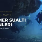 Berrak sularda bir sualtı mağarasından geçen dalgıçlar